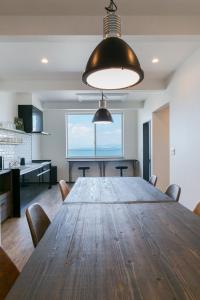 a dining room with a large wooden table and chairs at Guest House Diphylleia Grayi in Hatsukaichi