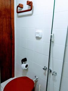 a bathroom with a red toilet and a shower at Flat Barra in Salvador