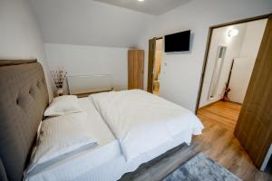 カリマネシュティにあるCasa Anaのベッドルーム(白いベッド1台、鏡付)