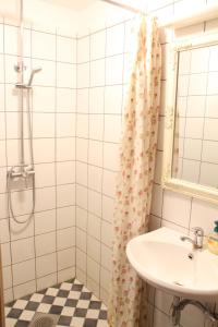 een badkamer met een wastafel en een douche bij Villa ÕU apartments in Pärnu