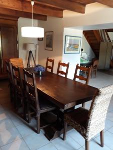 Le Mesnil-Aubert的住宿－Chambres d'hôtes Au Hameau，一间带木桌和椅子的用餐室