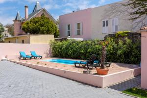 a swimming pool with two chairs and a house at Aguda Beach Charming House By PortoProperties4You in Vila Nova de Gaia
