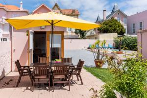 - une table et des chaises sous un parasol sur la terrasse dans l'établissement Aguda Beach Charming House By PortoProperties4You, à Vila Nova de Gaia