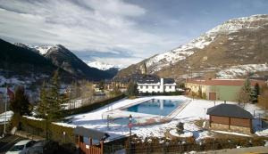 a large swimming pool with snow on the ground at Albergue Era Garona in Salardú