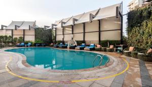 a swimming pool in front of a hotel at Radisson Gurugram Sohna Road City Center in Gurgaon
