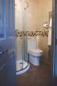 a bathroom with a toilet and a glass shower at The Throckmorton in Alcester
