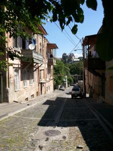 a cobblestone street in a town with a building at Vintage Art Rooms in Tbilisi City