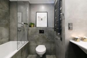 a bathroom with a shower toilet and a picture of a butterfly at Queen Boutique Hotel in Krakow