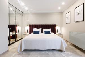 a bedroom with a large white bed with blue pillows at Queen Boutique Hotel in Krakow +53 photos