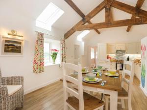 a kitchen and dining room with a wooden table and chairs at Bron Haul in Llanfairpwllgwyngyll