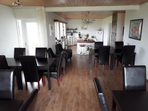a dining room with black tables and chairs at Guesthouse Geldingaholt in Árnes