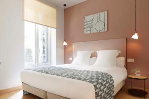 - une chambre avec un grand lit blanc et 2 fenêtres dans l'établissement Haizea by FeelFree Rentals, à Saint-Sébastien