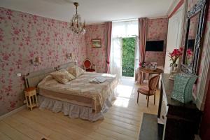 シャティヨン・シュル・セーヌにあるAuberge des Capucinsのピンクの壁紙を用いたベッドルーム1室