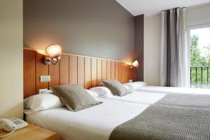 מיטה או מיטות בחדר ב-Hotel Iriguibel Huarte Pamplona