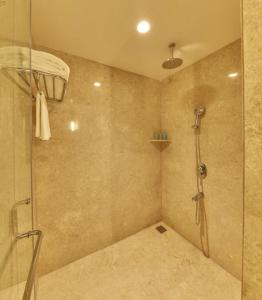uma casa de banho com um chuveiro e uma porta de vidro em The Waverly Hotel & Residences em Bangalore