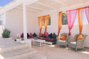 a screened in porch with a couch and chairs at Blue Kaouki in Sidi Kaouki