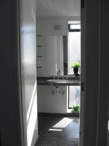 a white kitchen with a sink and a window at Vip Iracema Flat in Fortaleza
