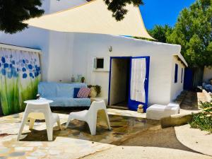a living room with a blue couch and white chairs at Sandra Studio in Lachania +21 photos
