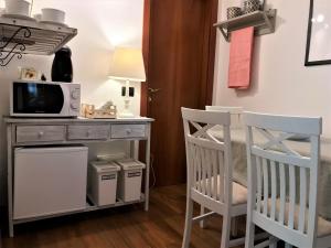 a room with two chairs and a table with a microwave at Green Corner Ulivo in Cavalcaselle