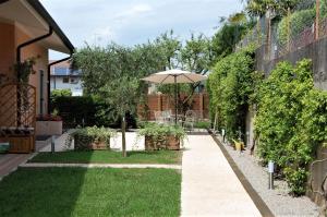 a garden with an umbrella and a lawn at Green Corner Ulivo in Cavalcaselle