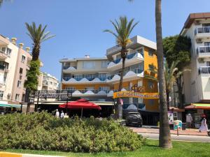 a building with palm trees in front of a street at Arsi Enfi City Beach Hotel in Alanya