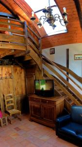 a living room with a tv and a staircase at Yourte Roulotte et Gite de la Laïta in Clohars-Carnoët