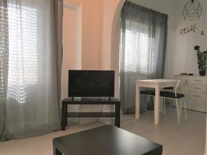 - un salon avec une télévision et une table dans l'établissement Caparica Sol, à Costa da Caparica