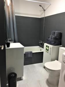 a bathroom with a toilet and a sink and a bath tub at Caparica Sol in Costa da Caparica