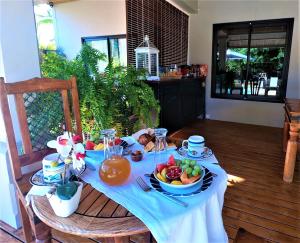 una mesa con un paño de mesa azul y un tazón de fruta en sweet island en Rivière Noire