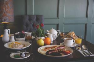 a table with plates of food on it with oranges and juice at The Mill at Conder Green in Conder Green