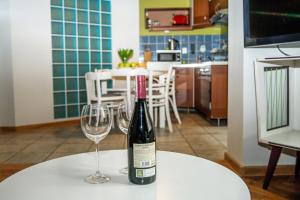 eine Flasche Wein auf einem Tisch mit zwei Weingläsern in der Unterkunft Red Kurka Apartments in Krakau