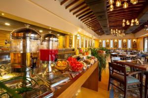 a restaurant with a counter with food and a buffet at Marquis Beach Resort in Candolim