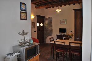 a living room with a television and a table with chairs at A Casa Del Tosi in Lucca