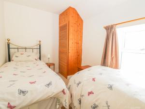 1 dormitorio con 2 camas y ventana en Dove Cottage en Whitby