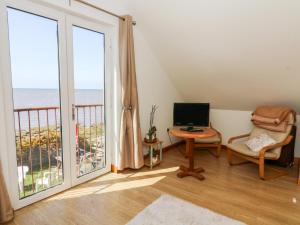 a living room with a computer and a balcony with the ocean at Shorefields One in Morecambe
