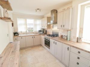 a kitchen with white cabinets and a counter top at Lilly May Cottage in Bridlington
