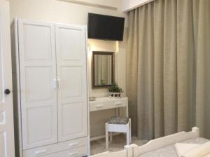 プラタニアスにあるMaria Suitesの白いドア、化粧台、鏡が備わるベッドルーム1室が備わります。