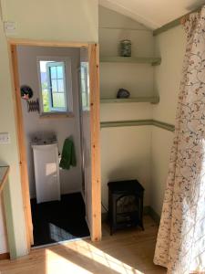 a room with a door open to a room with a window at Hillcrest Hut in Tenby