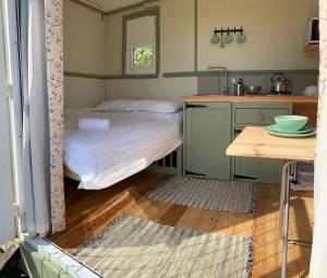 テンビーにあるHillcrest Hutの小さなベッドルーム(ベッド1台付)、キッチンが備わります。