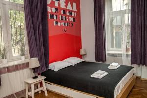 a bedroom with a bed with a red wall at Red Kurka Apartments in Krakow