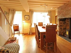 ein Esszimmer mit einem Tisch und ein Zimmer mit einem Kamin in der Unterkunft Cae'r Dyni Caer Dyni in Criccieth