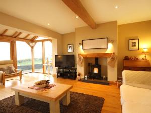 ein Wohnzimmer mit einem TV und einem Kamin in der Unterkunft Cae'r Dyni Caer Dyni in Criccieth