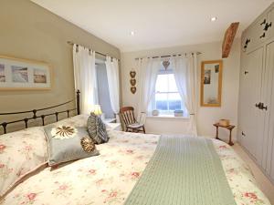 ein Schlafzimmer mit großem Bett und Fenster in der Unterkunft Cae'r Dyni Caer Dyni in Criccieth