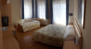 a hotel room with two beds and a television at Piccolo Fiore in Avio
