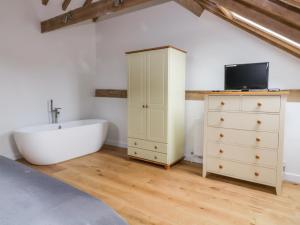 een slaapkamer met een bad en een dressoir bij Grange Barn in Hessett