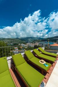 - une rangée de chaises longues vertes sur un balcon dans l'établissement Penthouse Leon, à Dubrovnik
