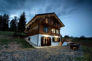 a large wooden house with a staircase leading up to it at Tulean Cabin in Săcel