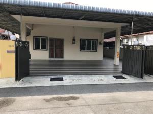 un edificio con un porche con dos puertas delante en 1248 Cozy Home, en Ipoh