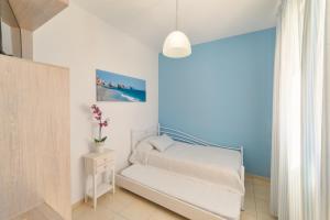 a small bedroom with a bed and a blue wall at Villa George Sea View with pool - Triopetra in Triopetra