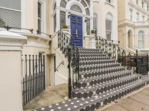 um conjunto de escadas em frente a uma casa com uma porta azul em Saltwood em Eastbourne